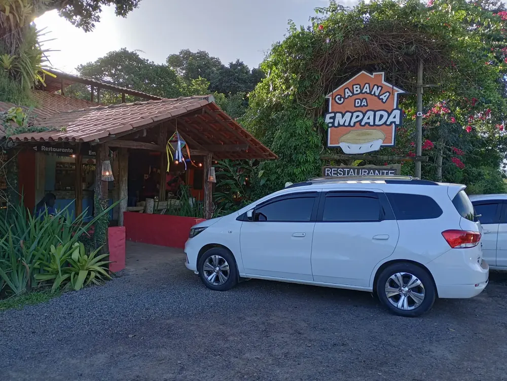 Veículo da Adário TÁXI E TURISMO estacionado em frente ao restaurante Cabana da Empada