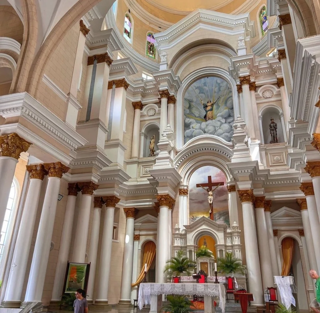 Interior de igreja em Ilhéus com altar, colunas ornamentadas e vitrais